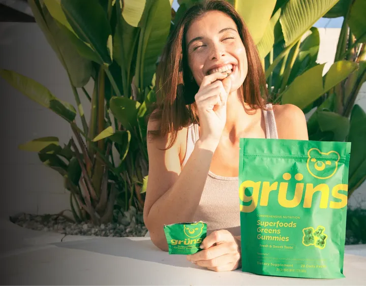 Woman eating gummy with Gruns product